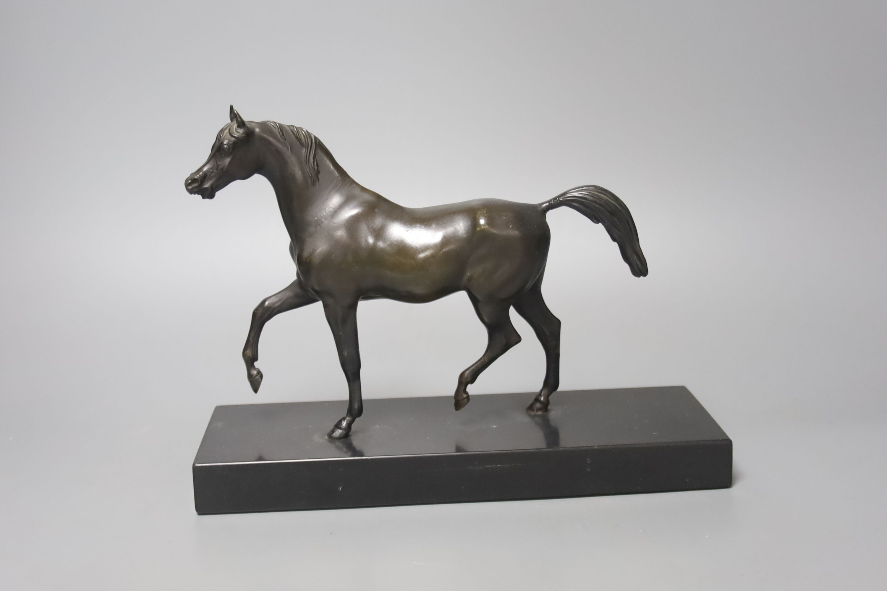 A bronze figure of a prancing horse, on a black marble plinth, 26cm
